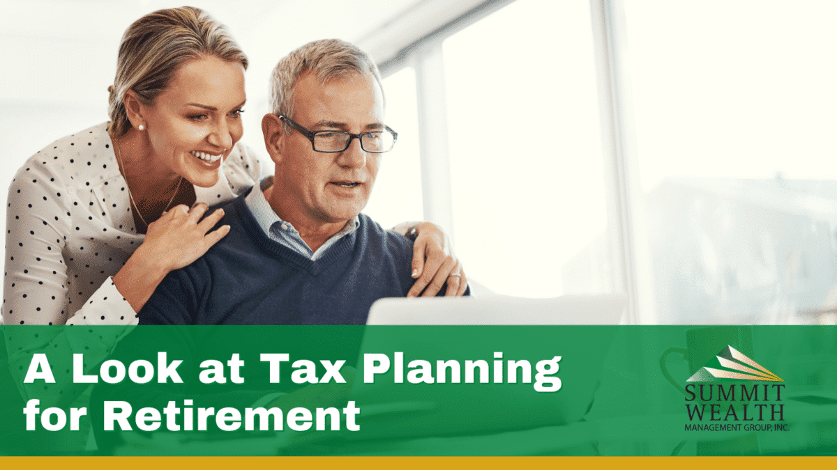 A couple reviews financial documents on a laptop, discussing tax planning strategies for retirement, in a bright and professional setting.